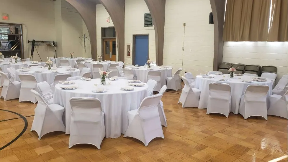 Hall with round tables and white stretch chair covers