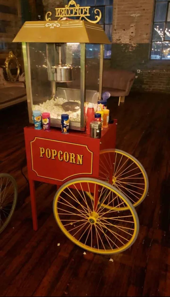 Popcorn machine on a red cart with yellow wheels