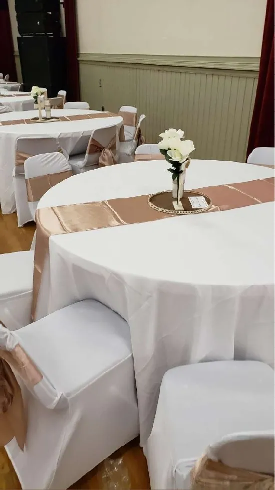 Round table with white tablecloth and a rose gold runner