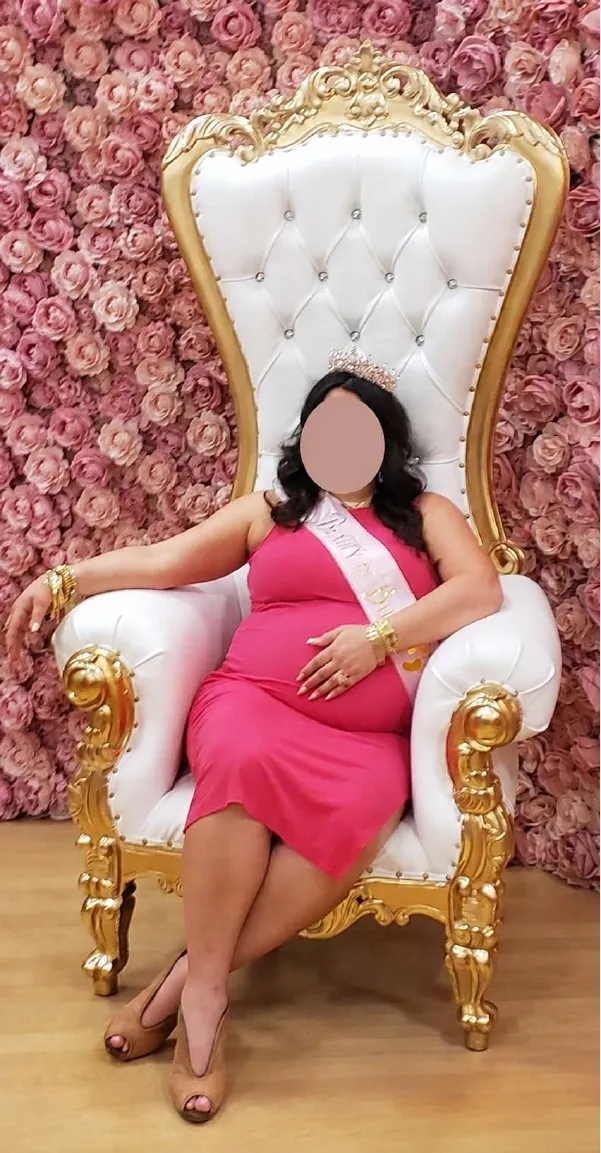 White and gold throne chair in front of a pink rose wall